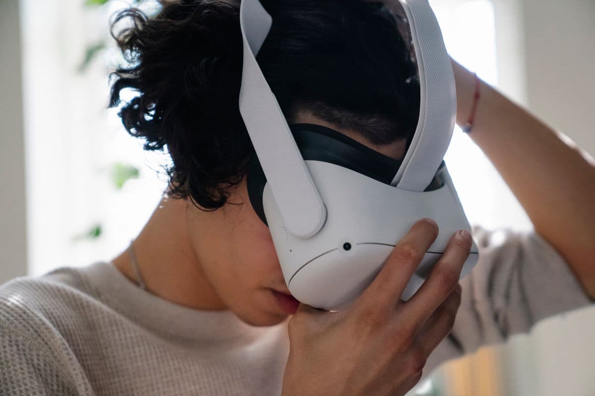 Person fitting a head-mounted headset, the kind of head-worn setup used in stereo camera egocentric data collection